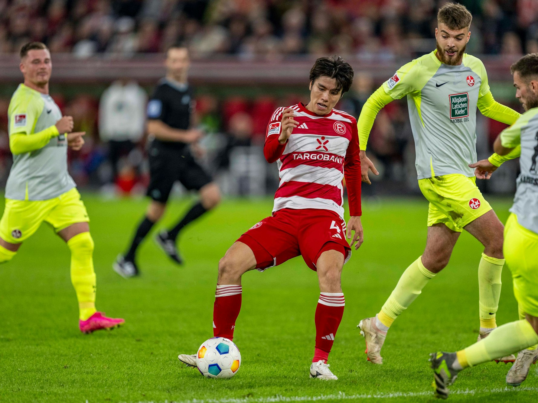 Ao Tanaka läuft mit dem Ball. Im Hintergrund: Kaiserslautern-Spieler.