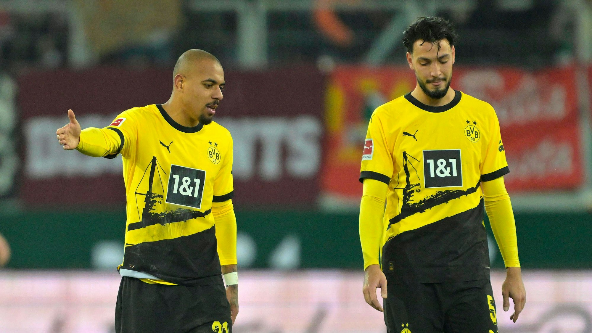 Ramy Bensebaini bespricht sich mit seinem BVB-Teamkollegen Donyell Malen.