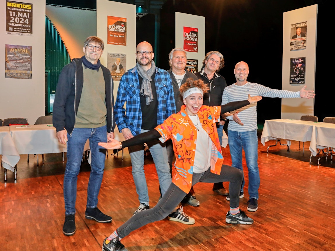 Künstler stehen nebeneiner in einem Raum.