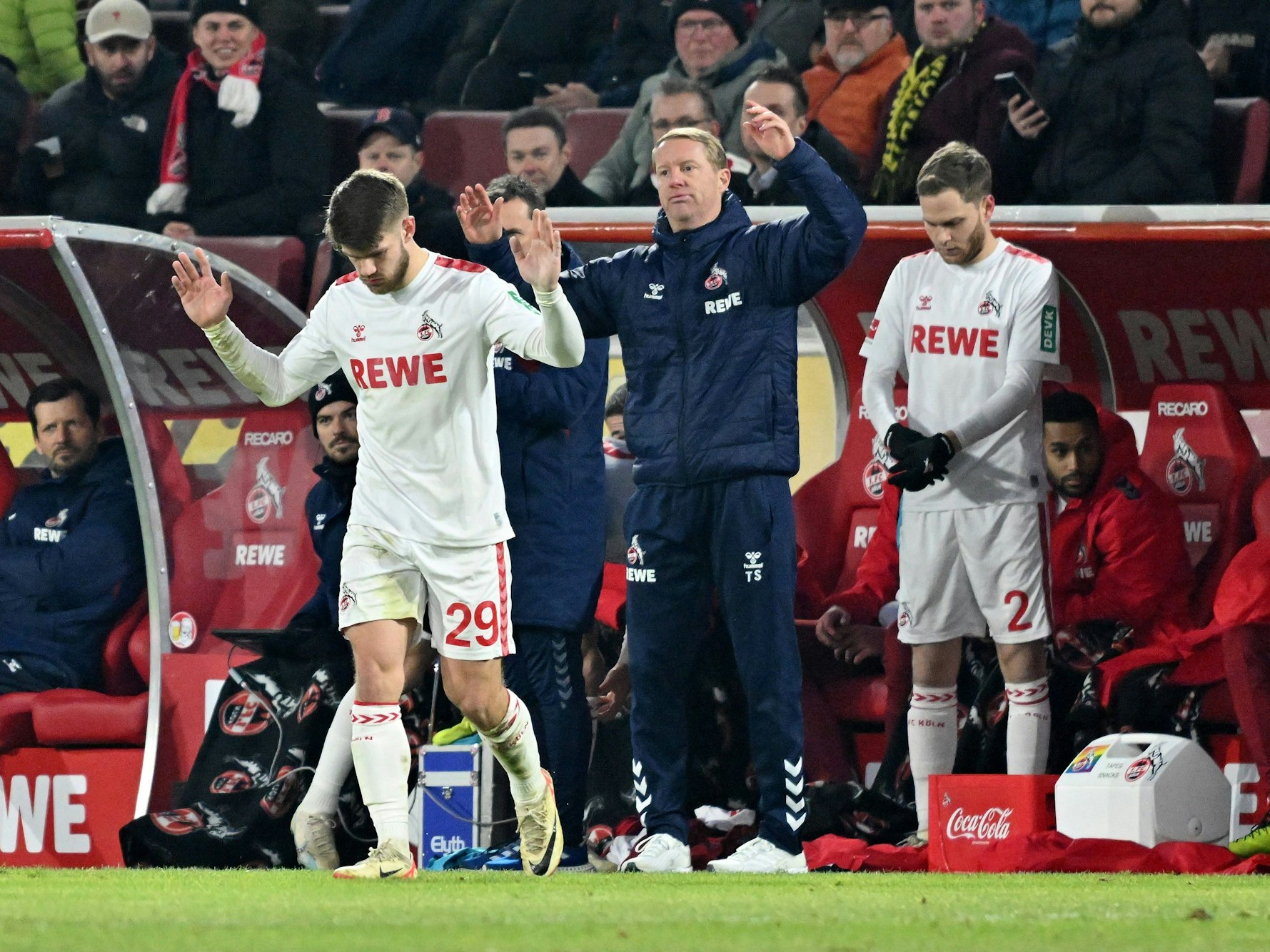Timo Schultz und Jan Thielmann gestikulieren an der Seitenlinie. Benno Schmitz bereitet sich auf seine Einwechslung vor.