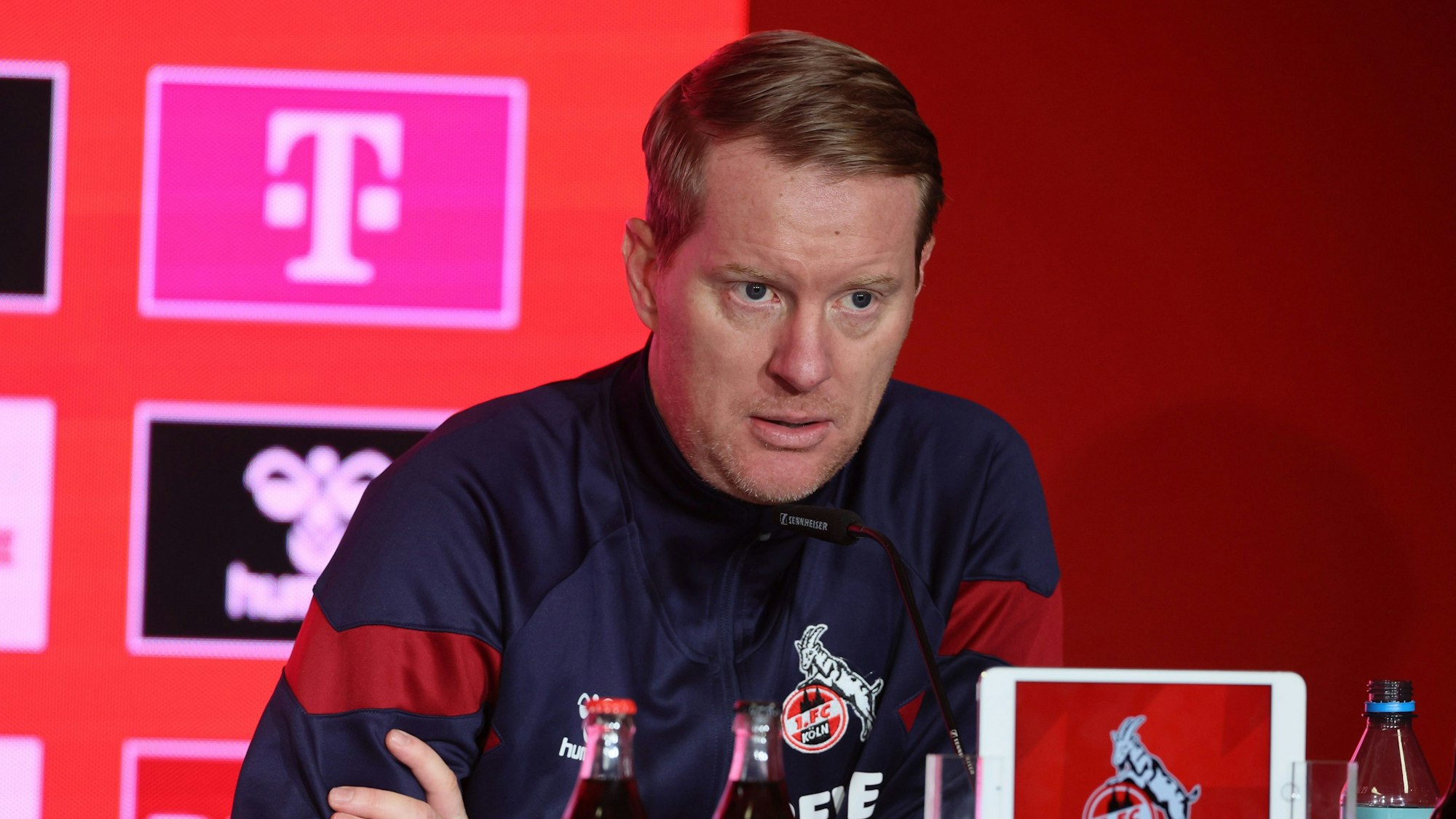 Timo Schultz sitzt bei einer Pressekonferenz am Rednerpult.