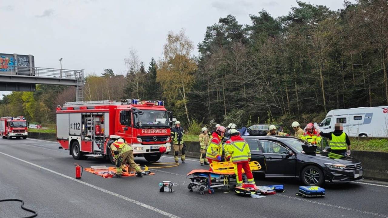 Zahlreiche Einsatzkräfte der Feuerwehr stehen an einem beschädigten Auto.