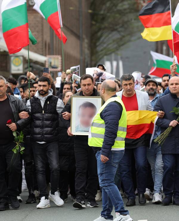 Mit bulgarischen und deutschen Flaggen zogen Teilnehmende am Samstag (30. März 2024) von der Innnenstadt zu dem ausgebrannten Haus, in dem eine aus Bulgarien stammende Familie ums Leben kam.