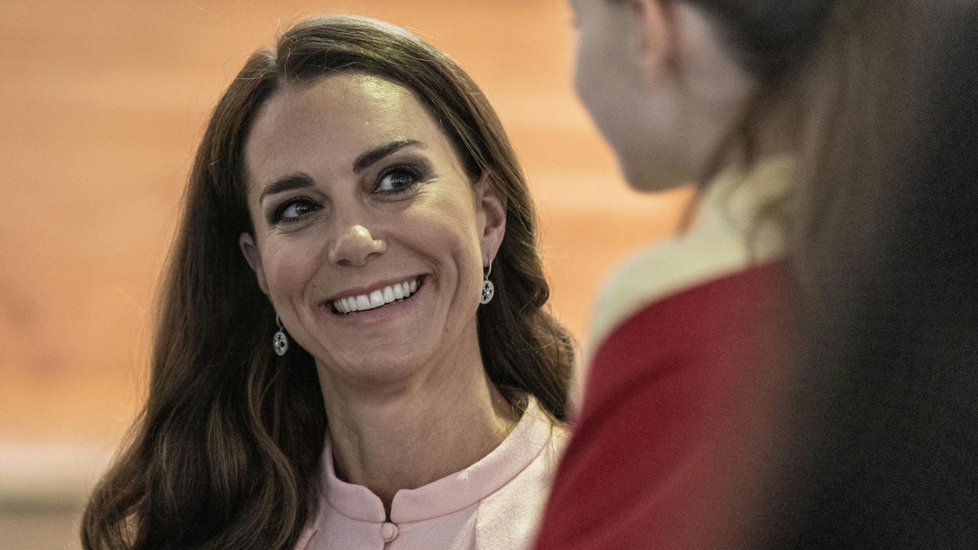 Prinzessin Kate lächelt ein Mädchen an.