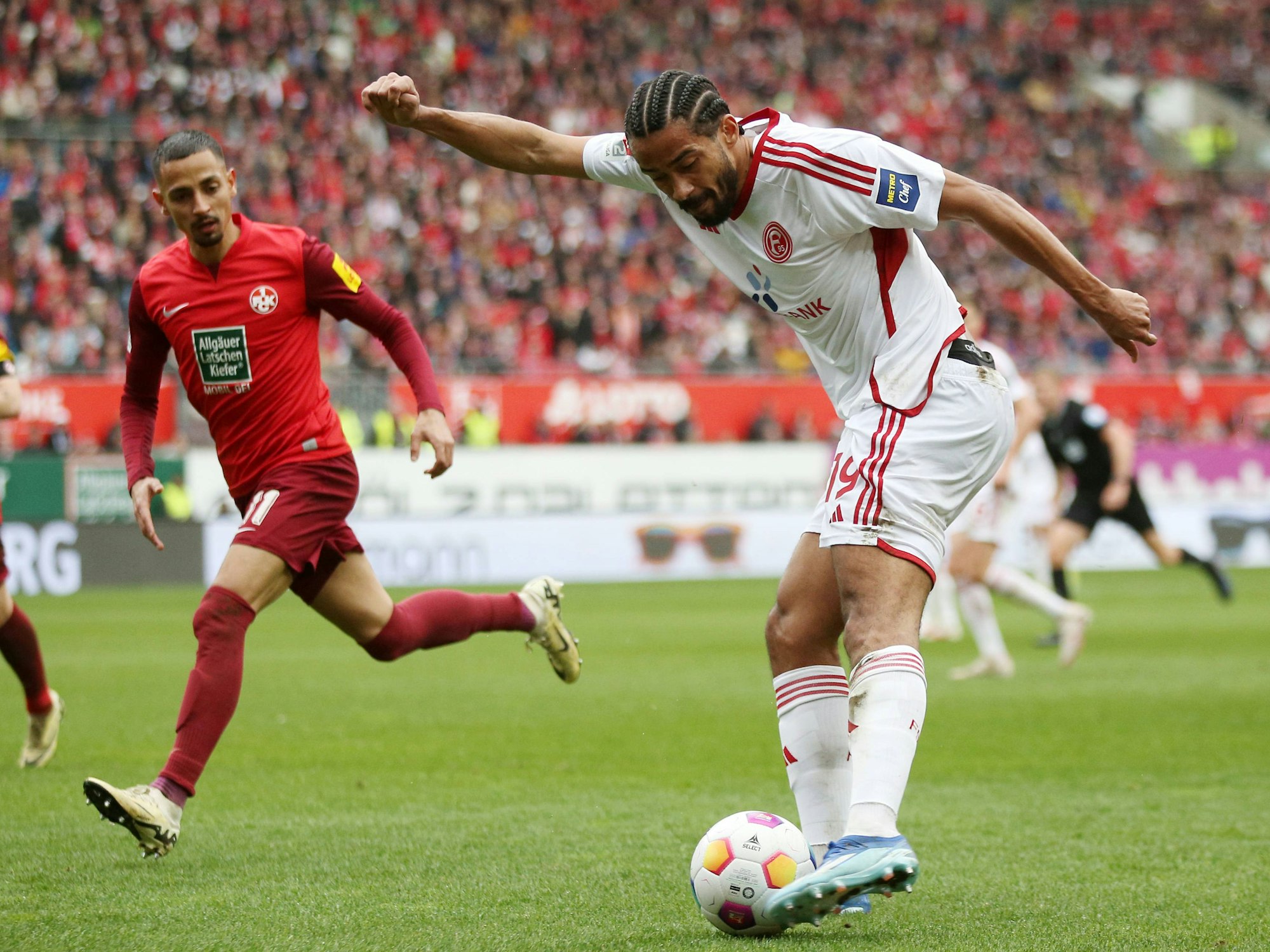 Fortuna Düsseldorfs Emmanuel Iyoha flankt, Kaiserslauterns Kenny Prince Redondo schaut zu.