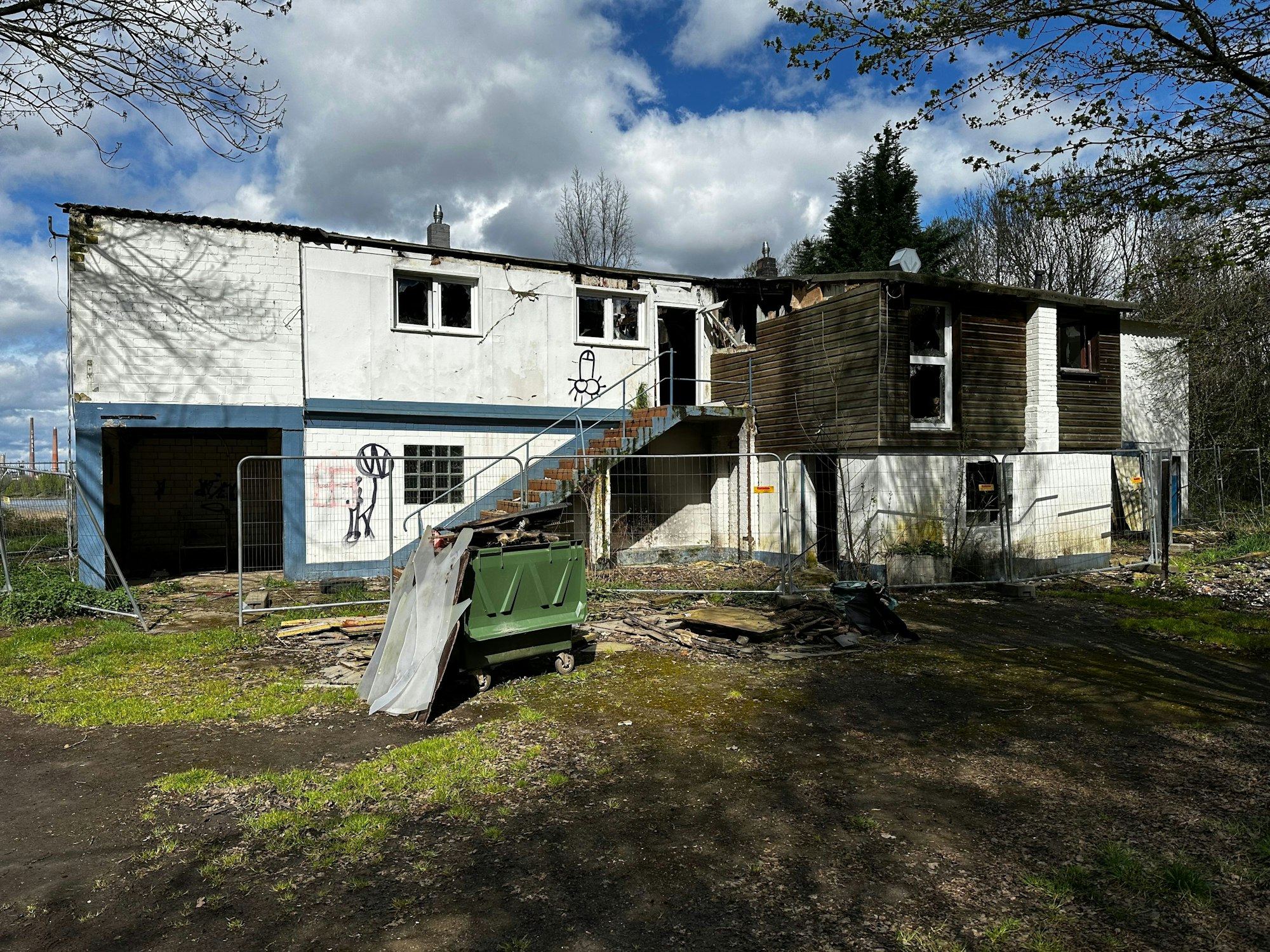 Ein verfallenes Gebäude ist mit einem Metallzaun abgesperrt.