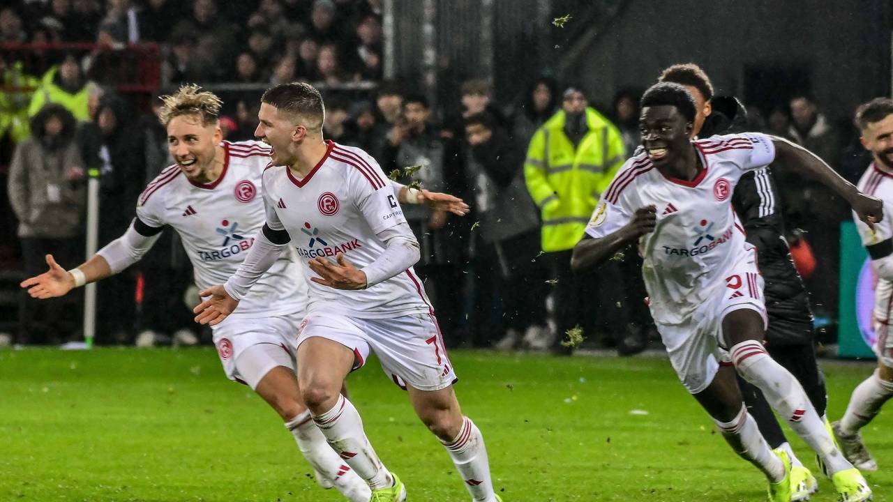 Christos Tzolis hat den Elfmeter zum Sieg eingenetzt und jubelt mit Jona Niemiec und Joshua Quarshie von Fortuna Düsseldorf.