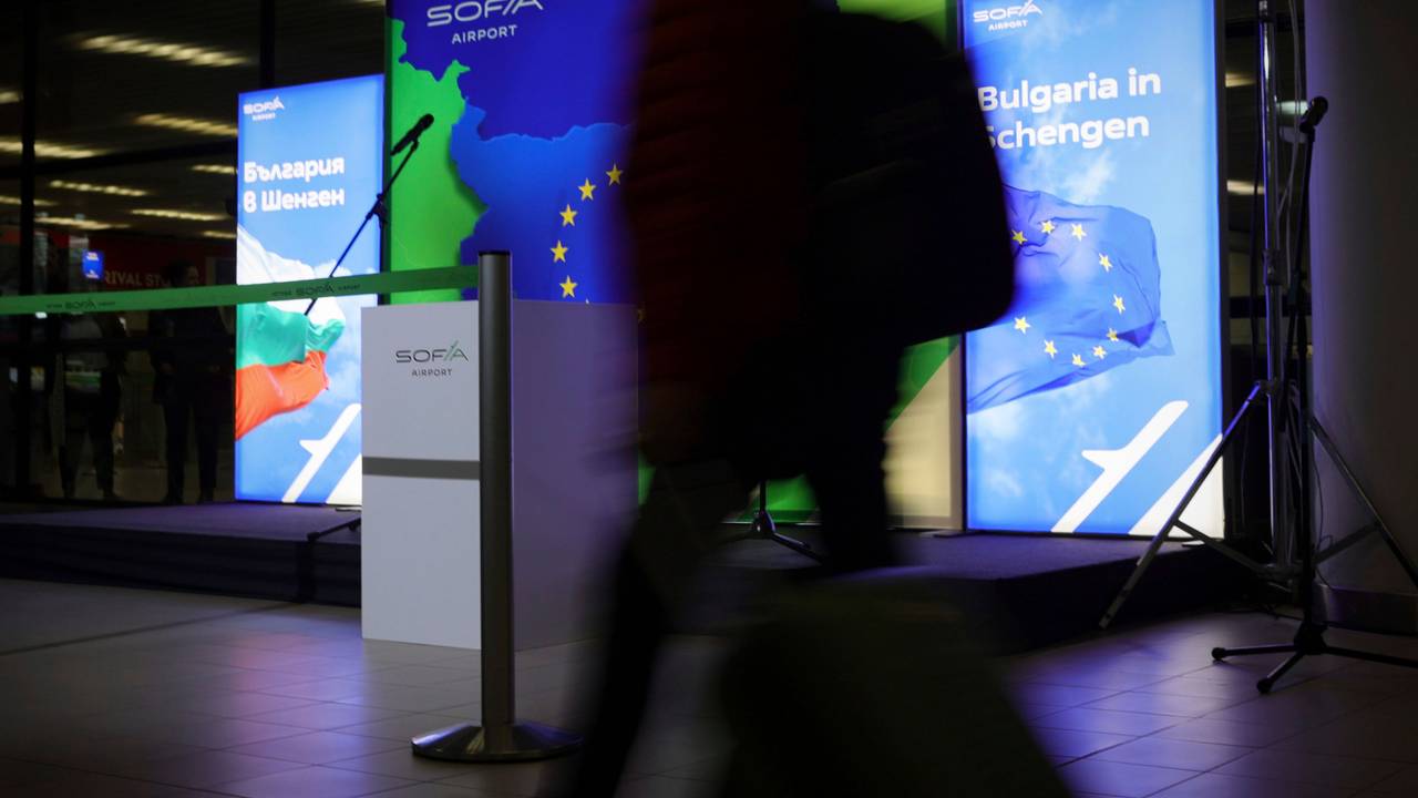 Passagiere laufen neben Plakaten, die den Beitritt Bulgariens zum Schengen-Raum auf dem Luft- und Wasserweg ankündigen.