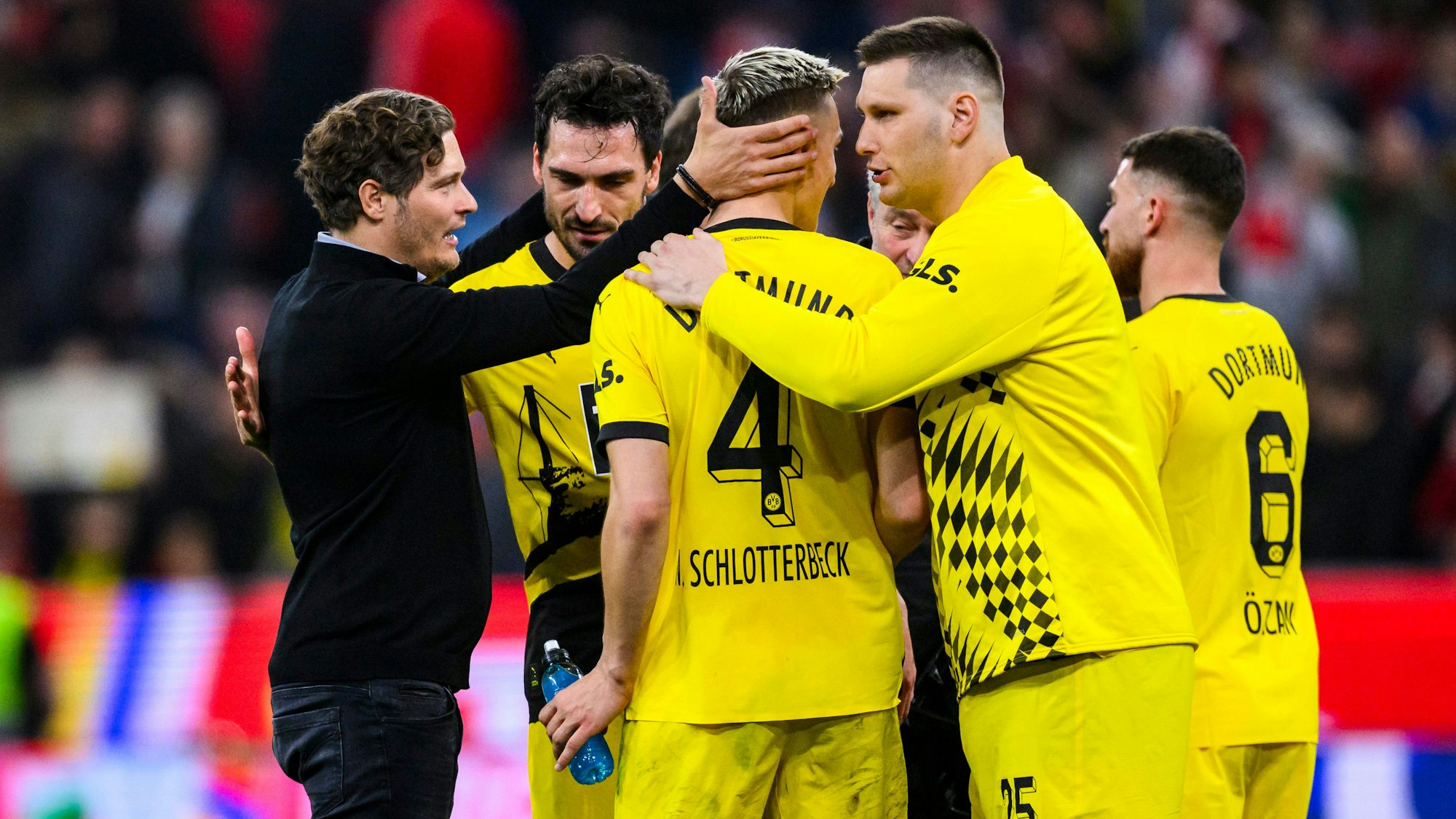 Edin Terzic beglückwünscht sein Abwehr-Duo Mats Hummels (2.v.l.) und Nico Schlotterbeck (M.) für die starke Leistung beim BVB-Sieg beim FC Bayern.