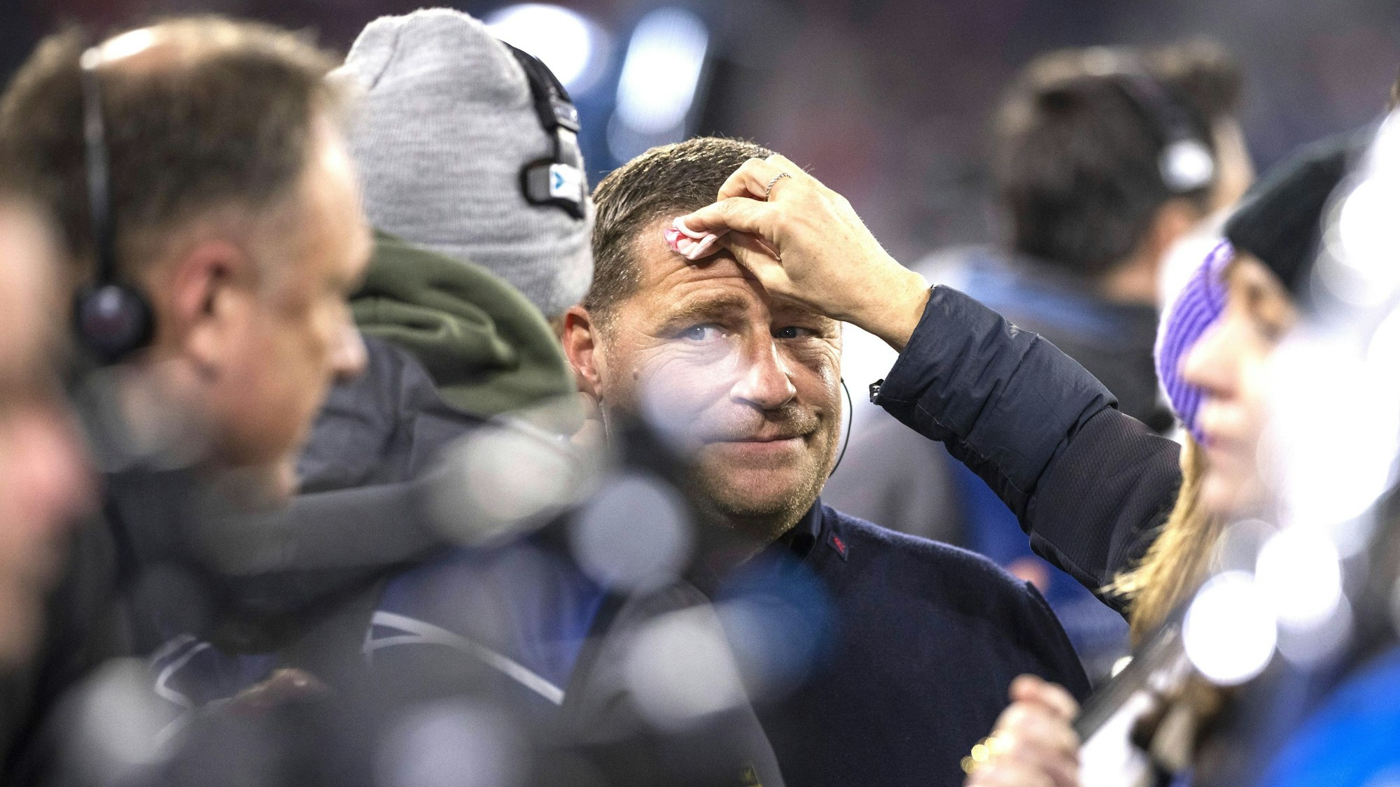 Max Eberl wird vor einem TV-Interview am Rande eines Spiels des FC Bayern abgetupft.