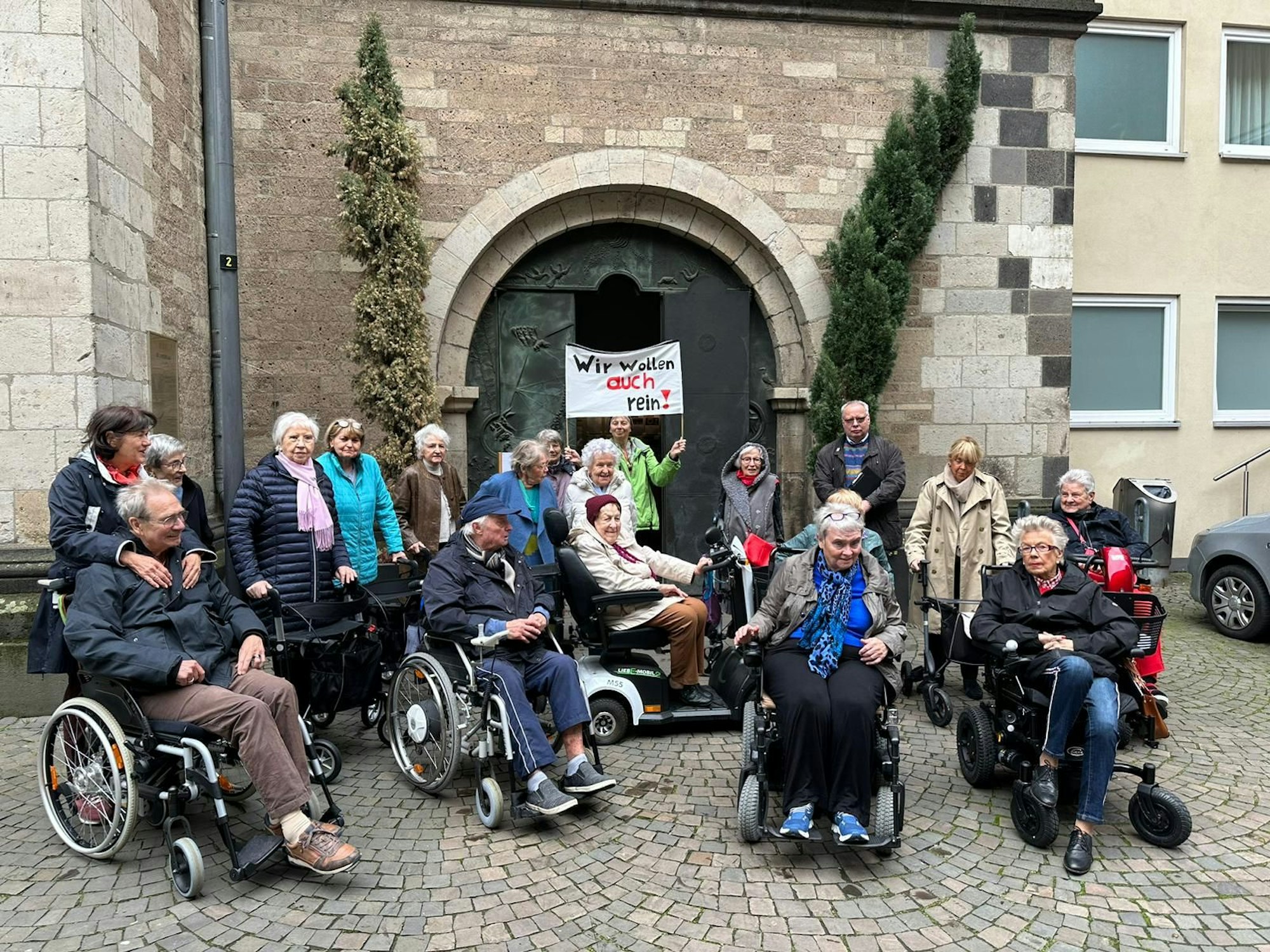 Eine Gruppe von Menschen bei einer Demo vor einer Kirche.