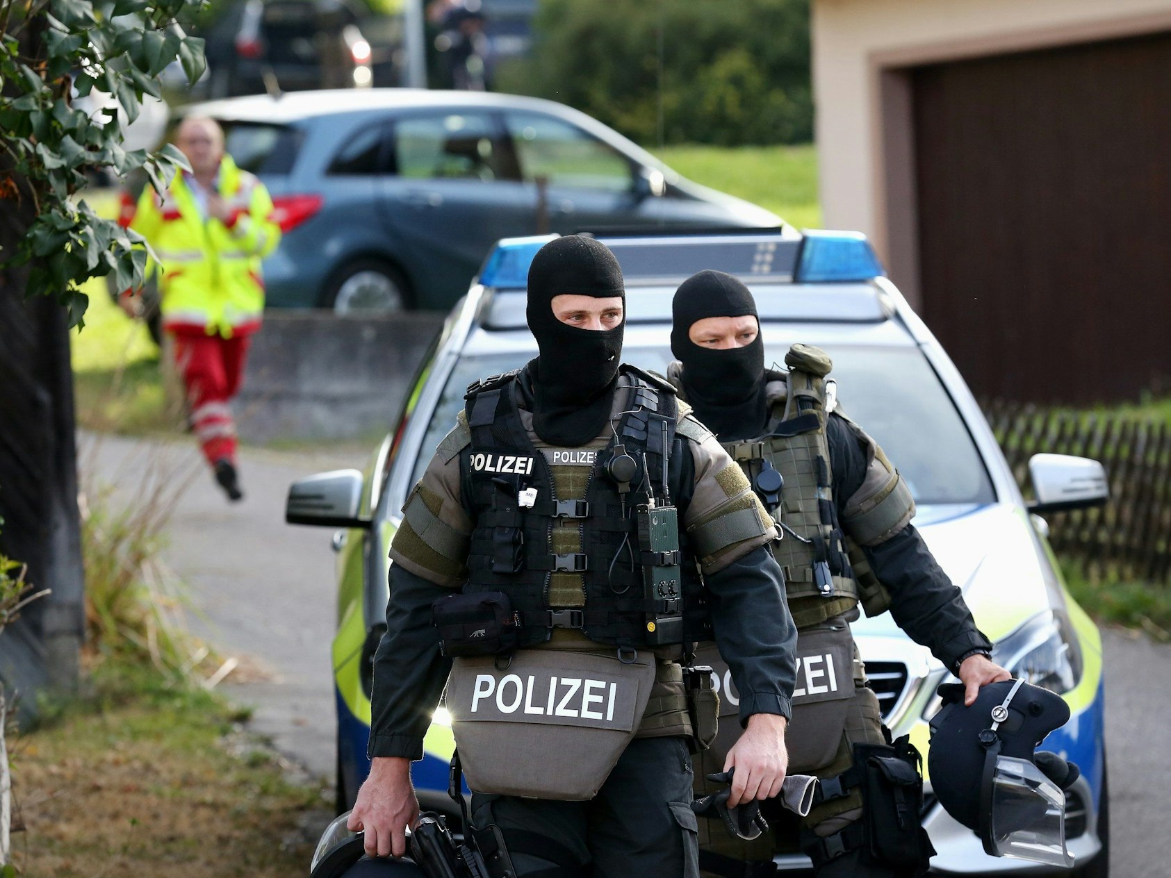 Zwei Beamte eines Spezialeinsatzkommandos (SEK) verlassen einen Tatort.