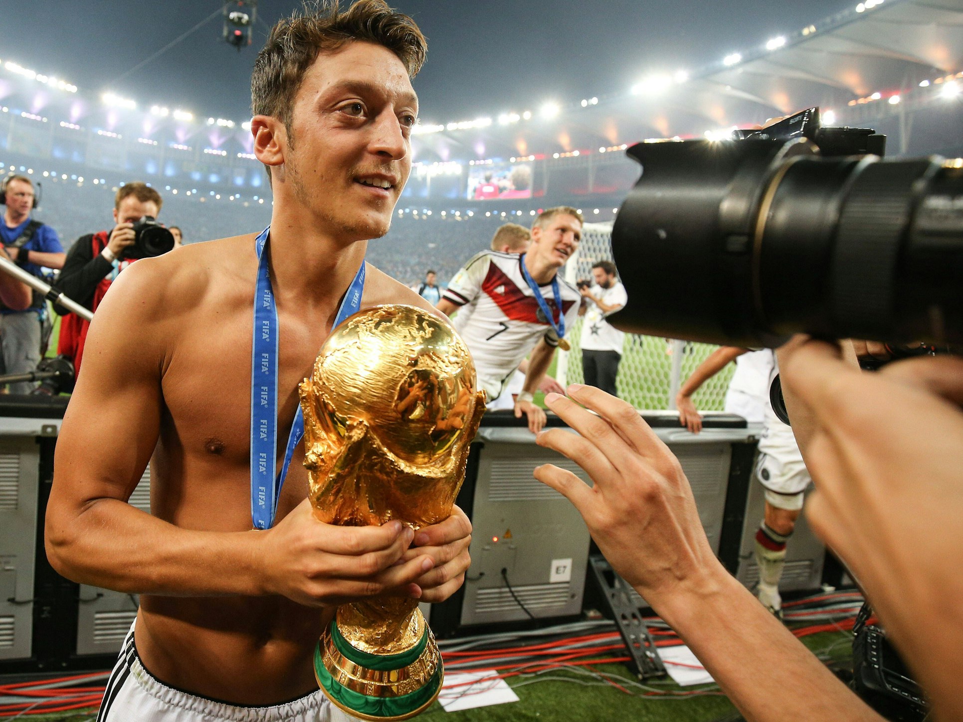 Mesut Özil feiert oberkörperfrei und mit dem WM-Pokal im Arm den Weltmeistertitel mit Deutschland.