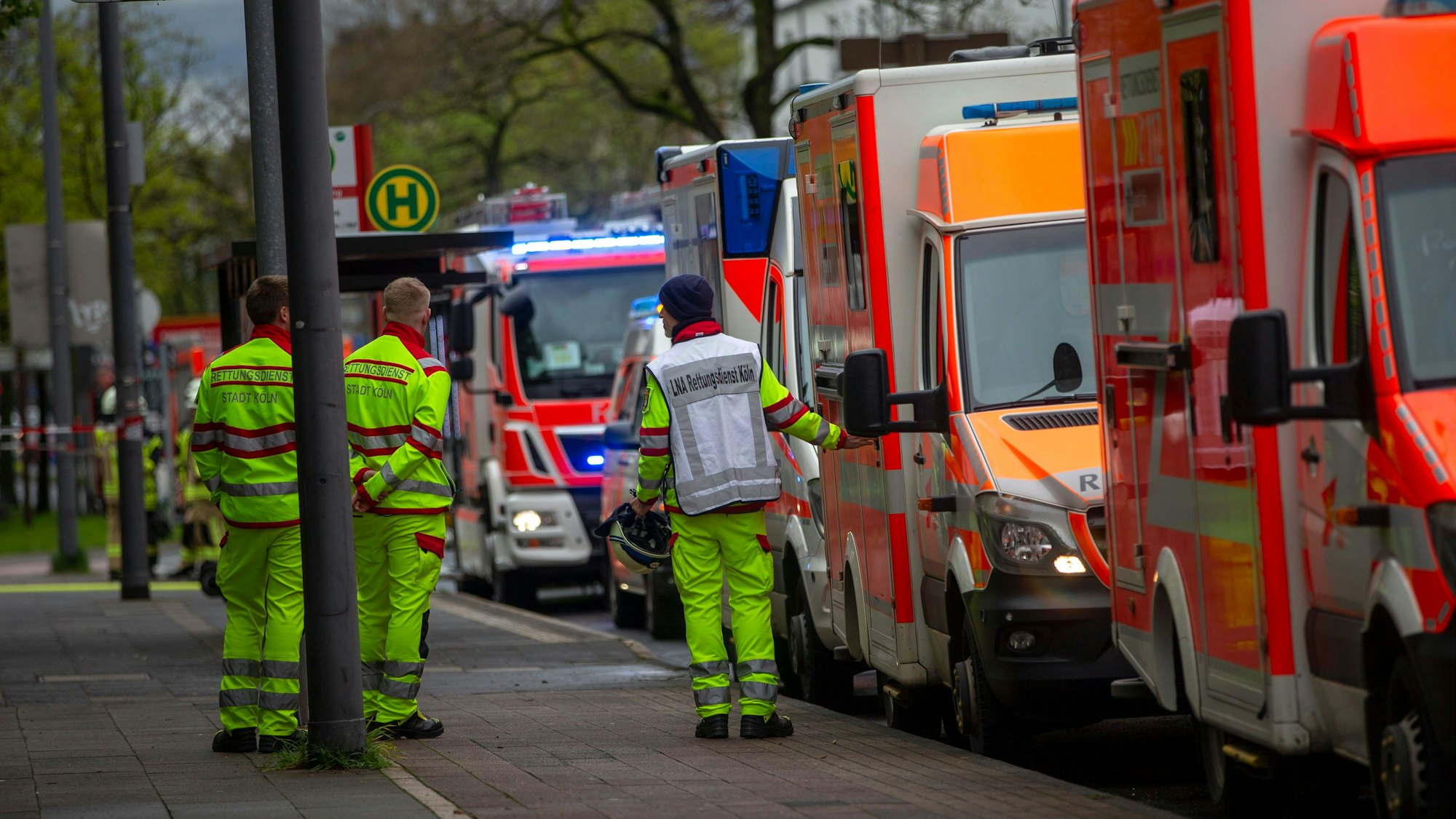 Fahrzeuge und Sanitäter des Rettungsdienstes stehen an einer Straße.