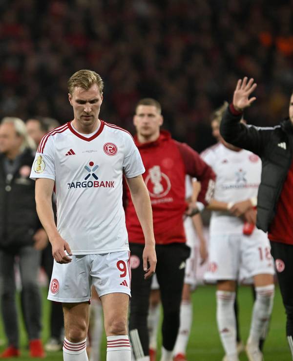 Die Spieler von Fortuna Düsseldorf laufen nach dem Pokal-Spiel in Leverkusen enttäuscht über den Platz.