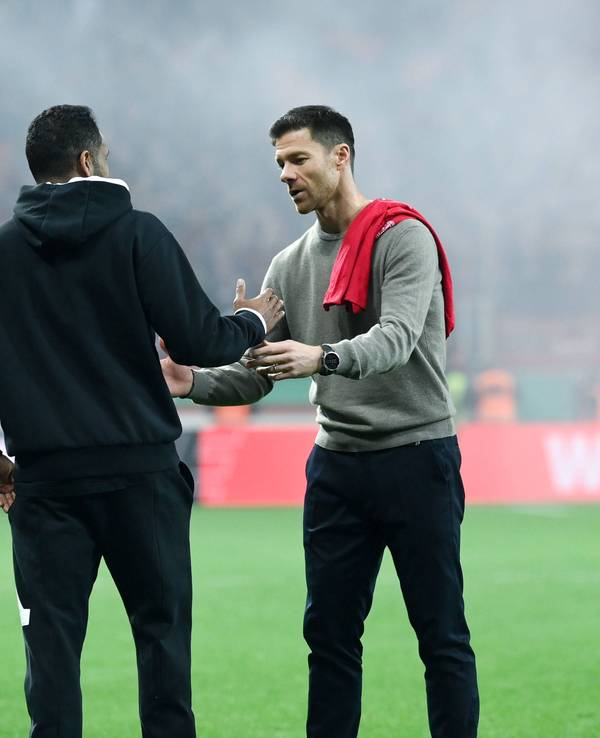 Bayer Leverkusens Trainer Xabi Alonso klatscht nach dem Halbfinalspiel gegen Fortuna Düsseldorf mit seinem Kollegen Daniel Thioune ab.