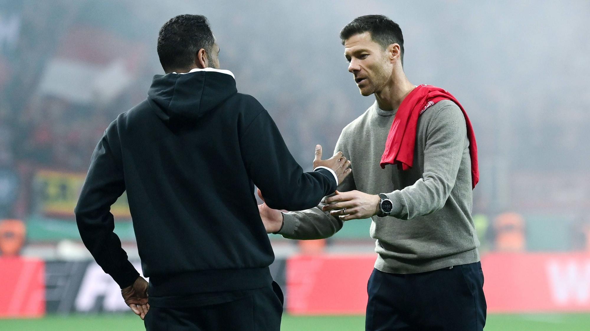 Bayer Leverkusens Trainer Xabi Alonso klatscht nach dem Halbfinalspiel gegen Fortuna Düsseldorf mit seinem Kollegen Daniel Thioune ab.
