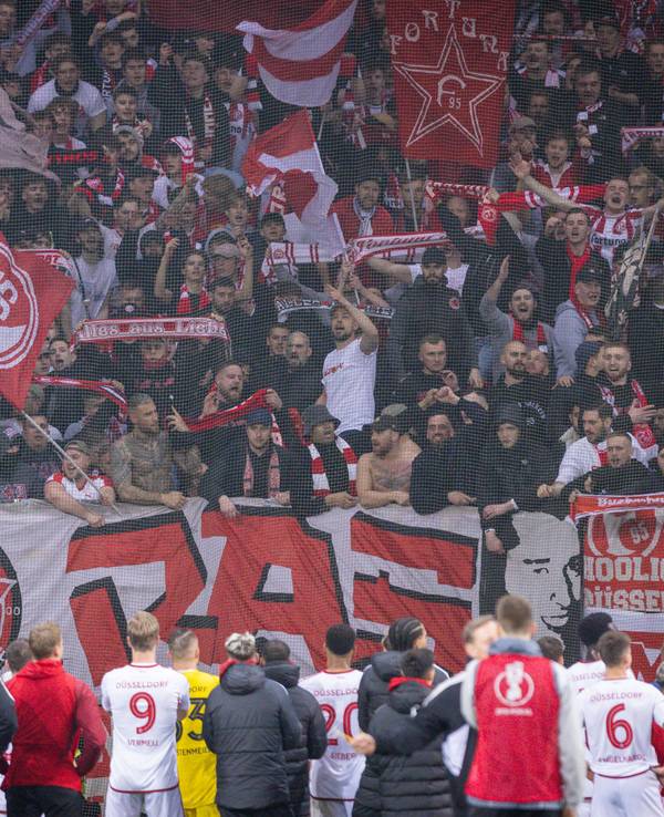 Die Fans von Fortuna Düsseldorf feiern ihr Team nach dem Pokal-Spiel bei Bayer Leverkusen in der Kurve.