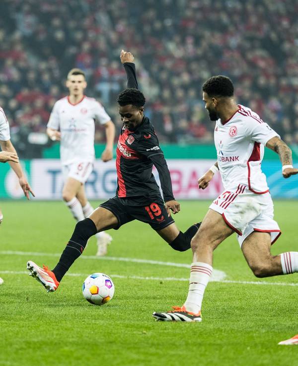 Nathan Tella schießt den Ball. Fortuna Düsseldorf Spieler stehen drumherum: Von l. n. r.: Matthias Zimmermann, Tim Oberdorf, Jamil Siebert.