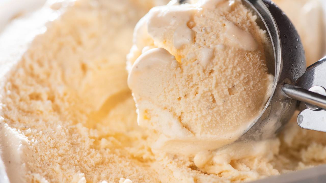 Ein Eislöffel in einer Packung mit Vanilleeis.
