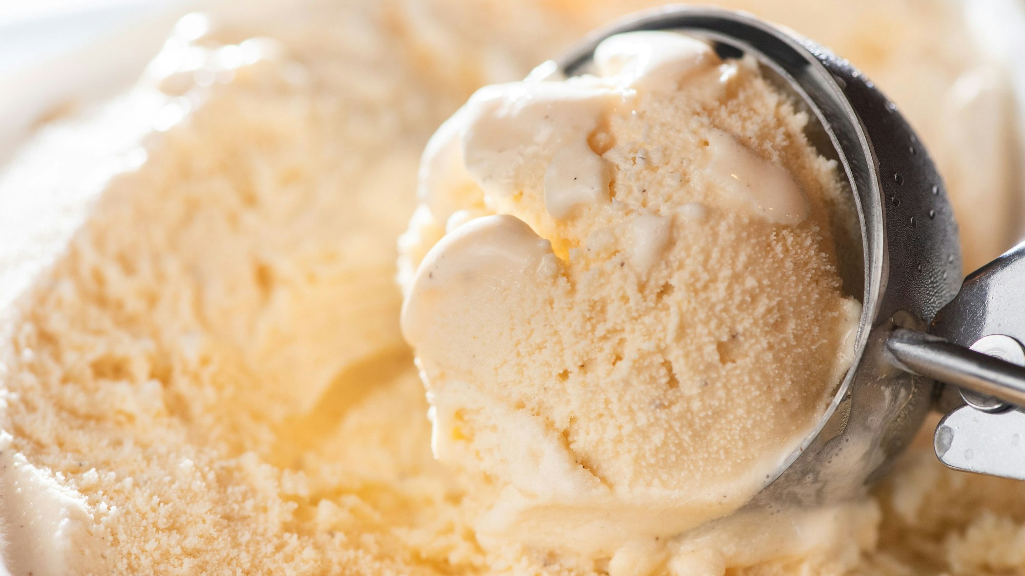 Ein Eislöffel in einer Packung mit Vanilleeis.