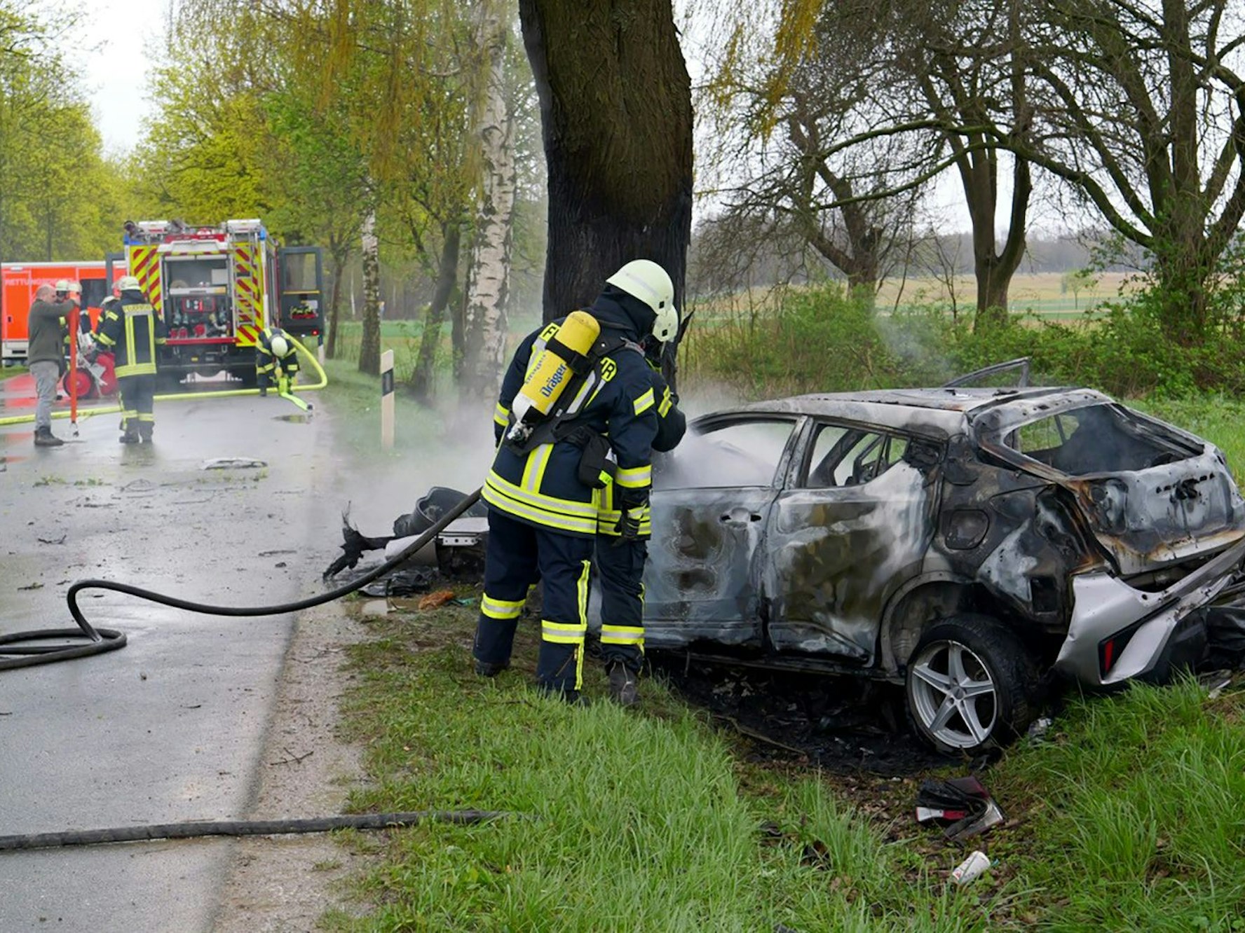 Ein ausgebranntes Auto steht an einem Baum im Straßengraben. Bei einem Unfall südwestlich von Paderborn ist am 4. April 2024 ein Ehepaar ums Leben gekommen.