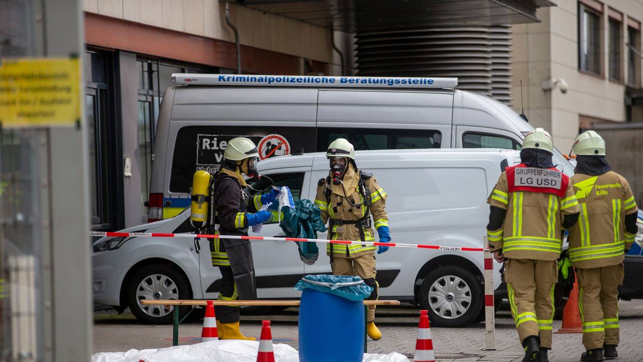 Einsatzkräfte der Feuerwehr stehen in einem abgesperrten Bereich.