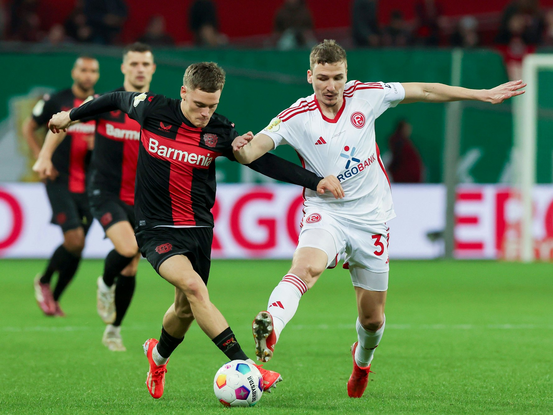 Fortuna Düsseldorfs Marcel Sobottka und Bayer Leverkusens Florian Wirtz kämpfen um den Ball.