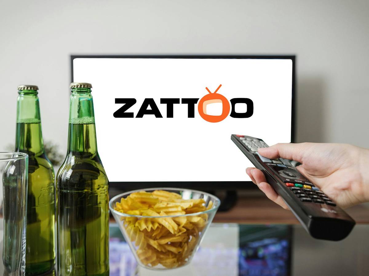 Fernseher mit Zattoo Logo. Im Vordergrund zwei Bierflaschen, eine Fernbedienung und Chips.