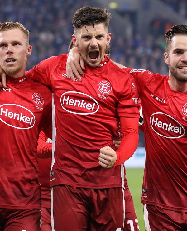 Fortuna Düsseldorfs Rouwen Hennings jubelt nach seinem Tor im Spiel beim FC Schalke 04 mit seinen Teamkollegen Dawid Kownacki und Niko Gießelmann.