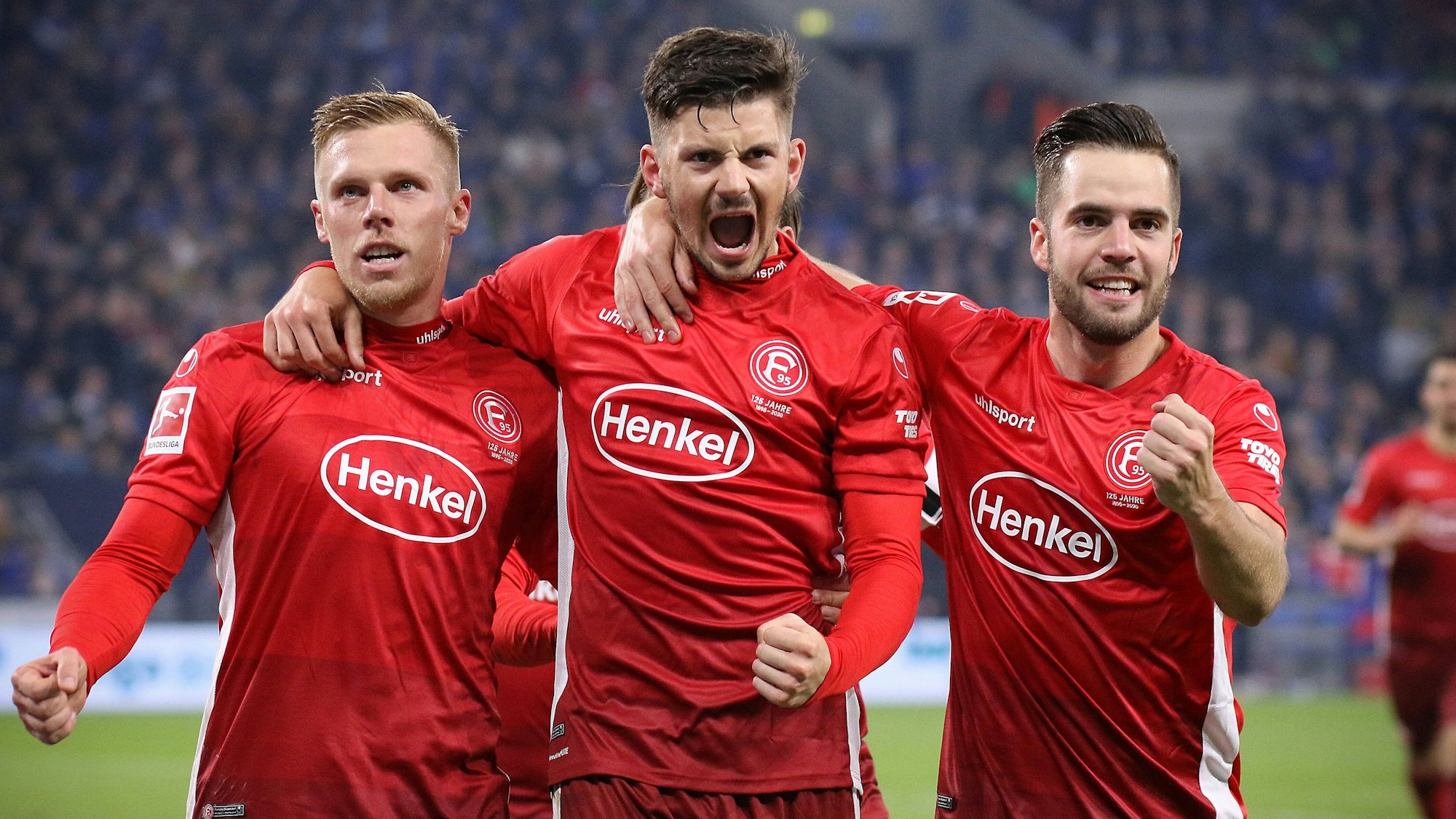 Fortuna Düsseldorfs Rouwen Hennings jubelt nach seinem Tor im Spiel beim FC Schalke 04 mit seinen Teamkollegen Dawid Kownacki und Niko Gießelmann.