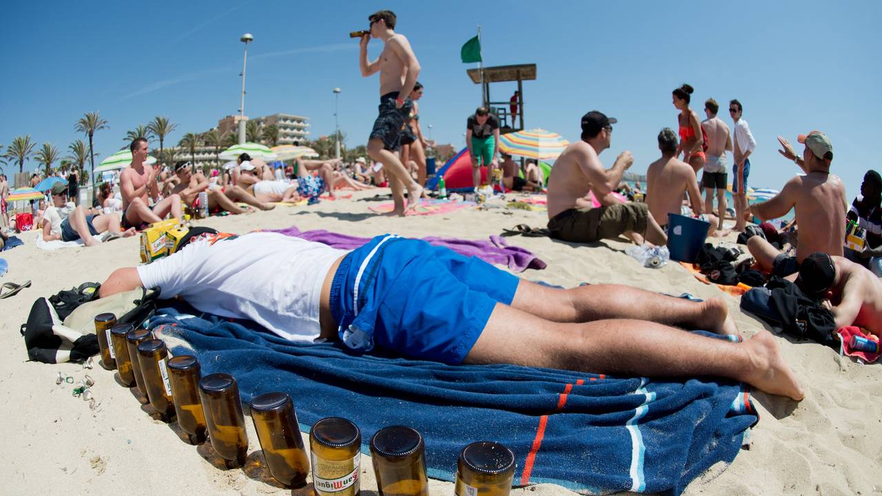 Ein deutscher Tourist liegt am 06.06.2013 schlafend auf einer Luftmatratze neben leeren Bierflaschen am Strand von Arenal auf der Mittelmeerinsel Mallorca.
