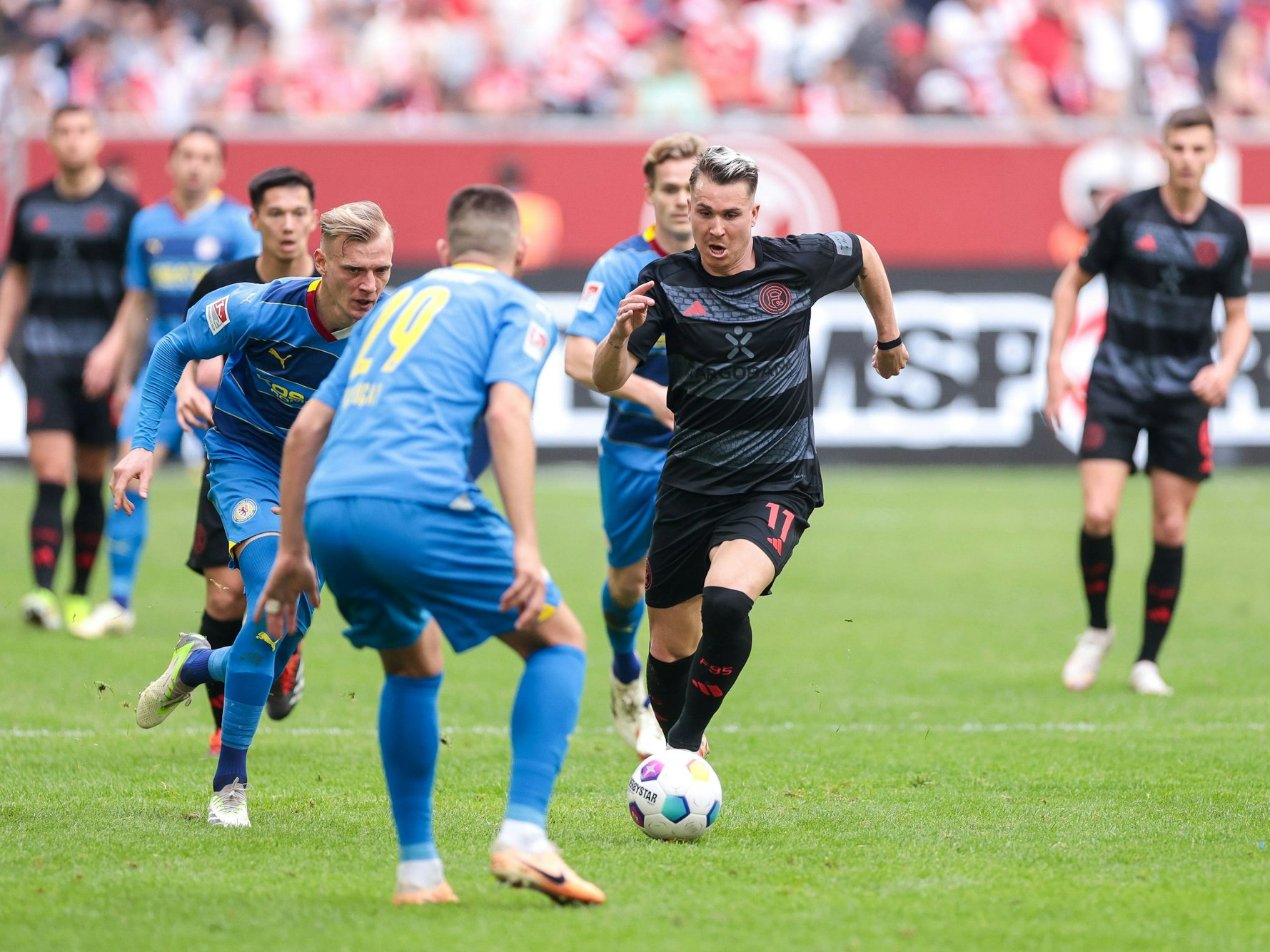 Felix Klaus rennt mit dem Ball an Eintracht Braunschweig-Spieler Hasan Kurucay vorbei.
