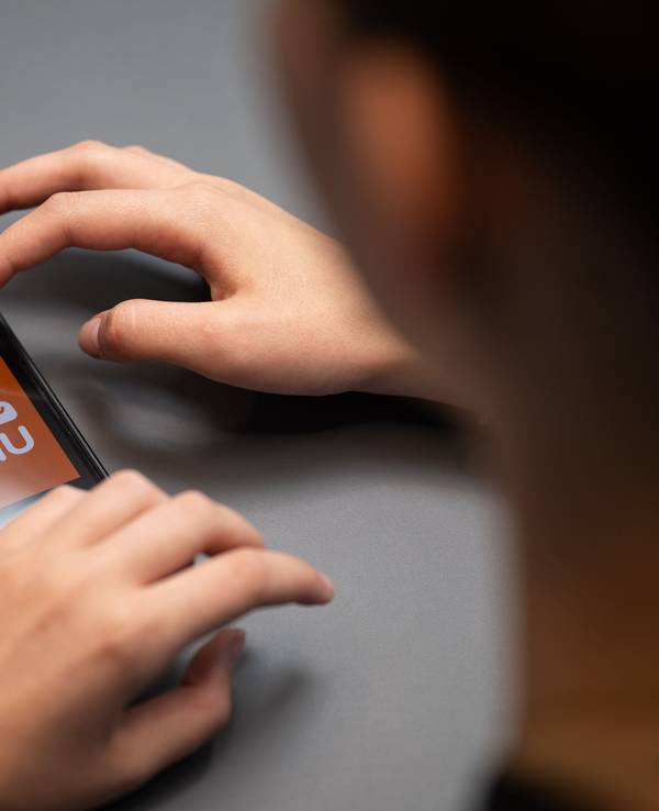 Eine Person hält ein Telefon mit der App Temu in den Händen, hier im August 2023 in Berlin.