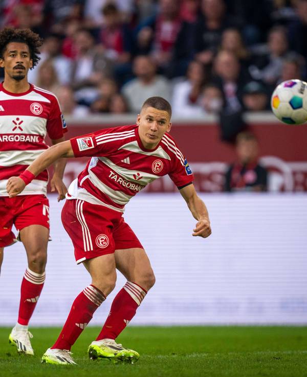 Emmanuel Iyoha und Christos Tzolis schauen den Ball an.