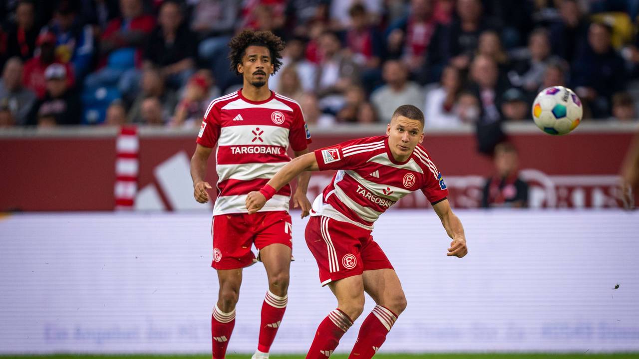 Emmanuel Iyoha und Christos Tzolis schauen den Ball an.