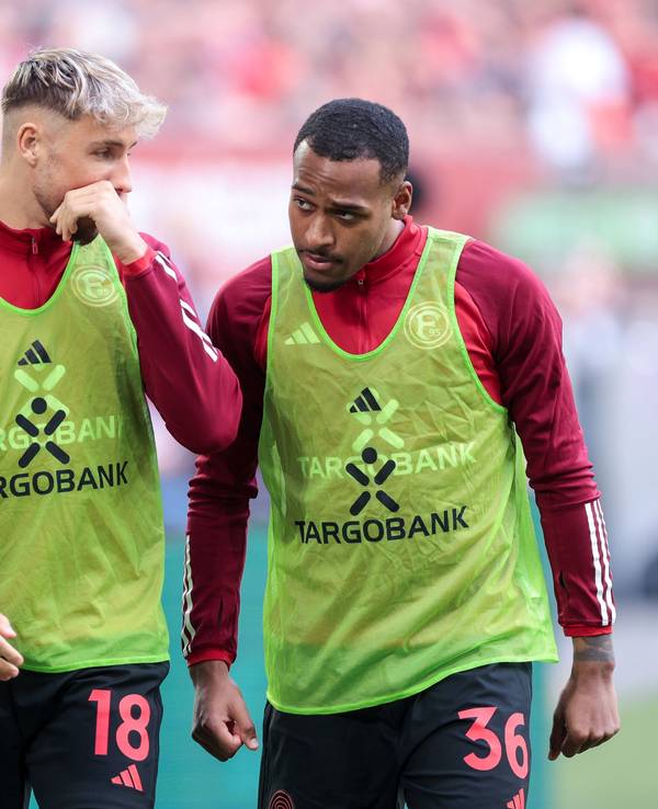 Die Düsseldorf-Profis Jona Niemiec und Marlon Mustapha unterhalten sich beim Aufwärmen am Seitenrand.