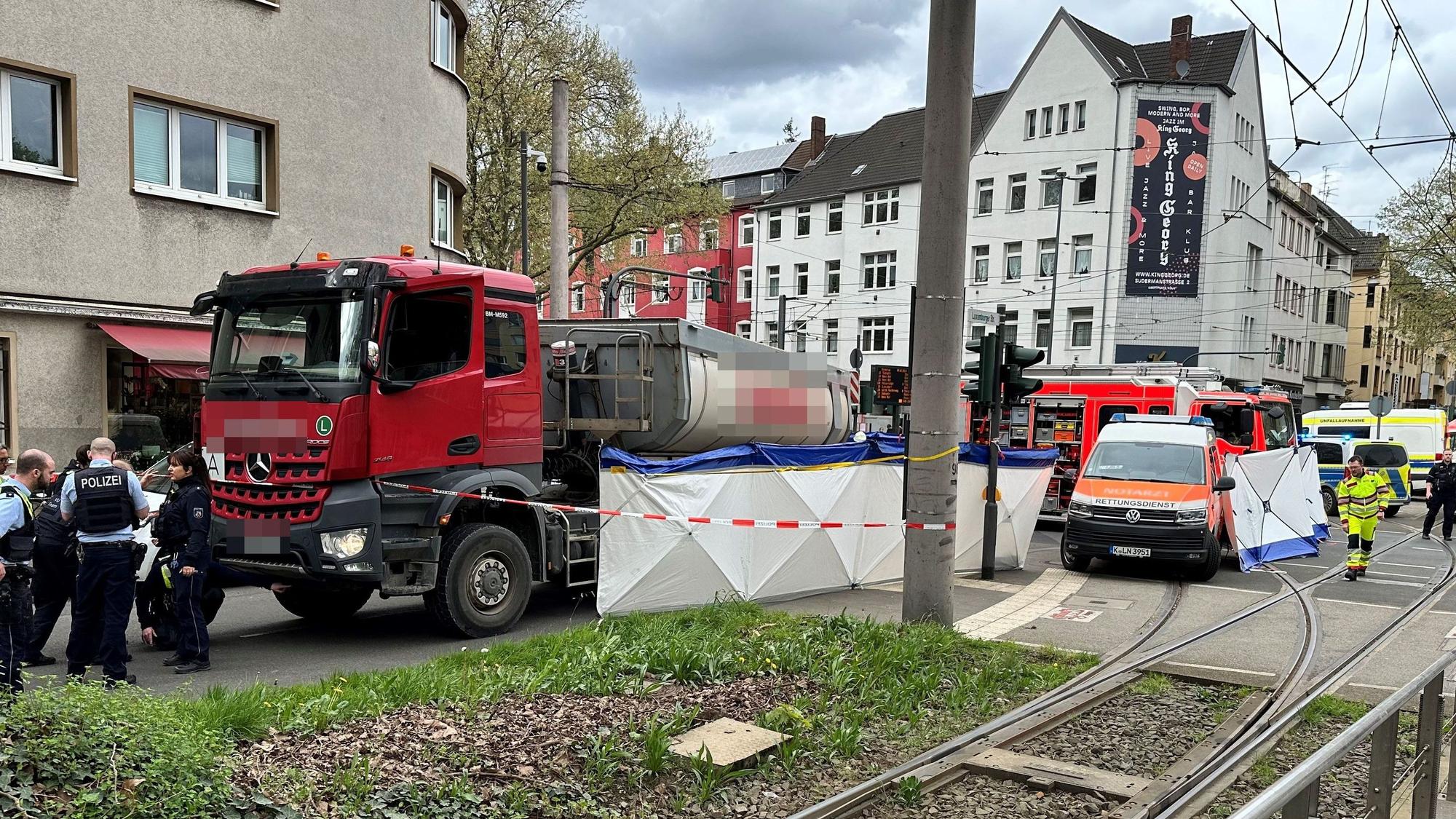 Ein Lkw steht auf einer Straße, an seiner Seite ein Sichtschutz. Die Polizei hat den Bereich abgesperrt.