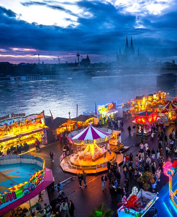 Die Deutzer Kirmes leuchtet in der Abenddämmerung