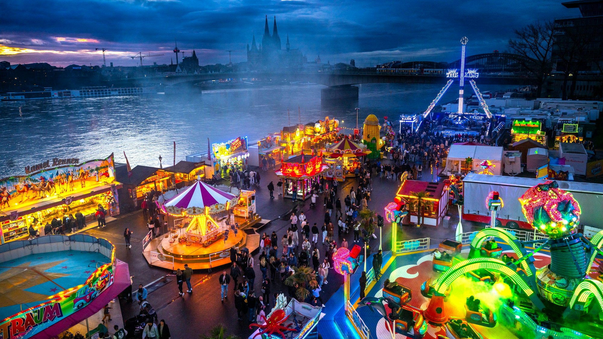 Die Deutzer Kirmes leuchtet in der Abenddämmerung