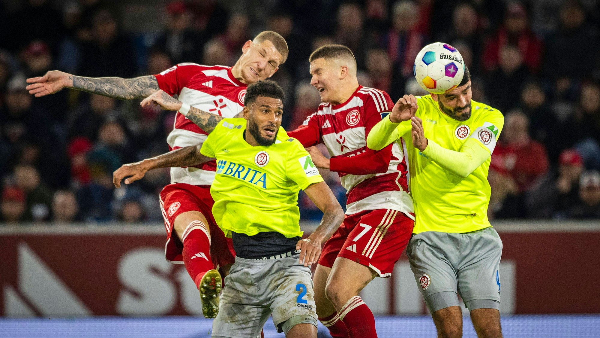 Jordy de Wijs und Christos Tzolis im Kopfball-Duell mit zwei Wiesbaden-Spielern.