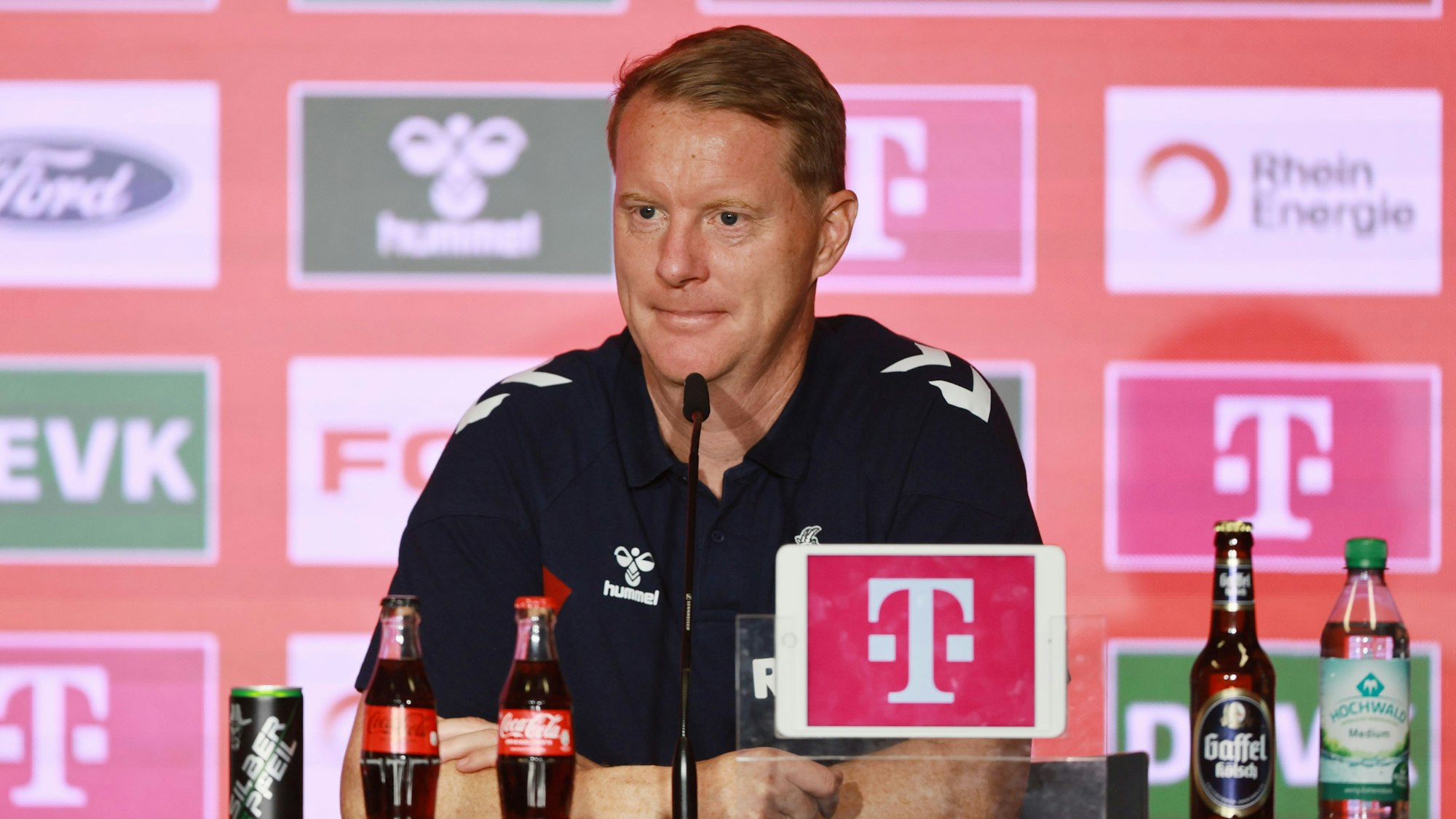 Timo Schultz sitzt bei einer Pressekonferenz am Rednerpult.