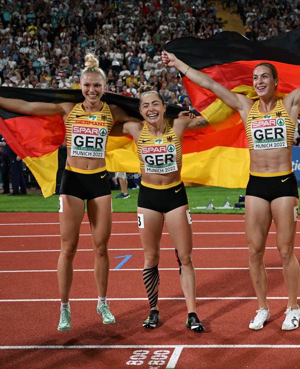 Lisa Mayer, Gina Lückenkemper, Alexandra Burghardt und Rebekka Haase jubeln mit Deutschland-Fahnen.