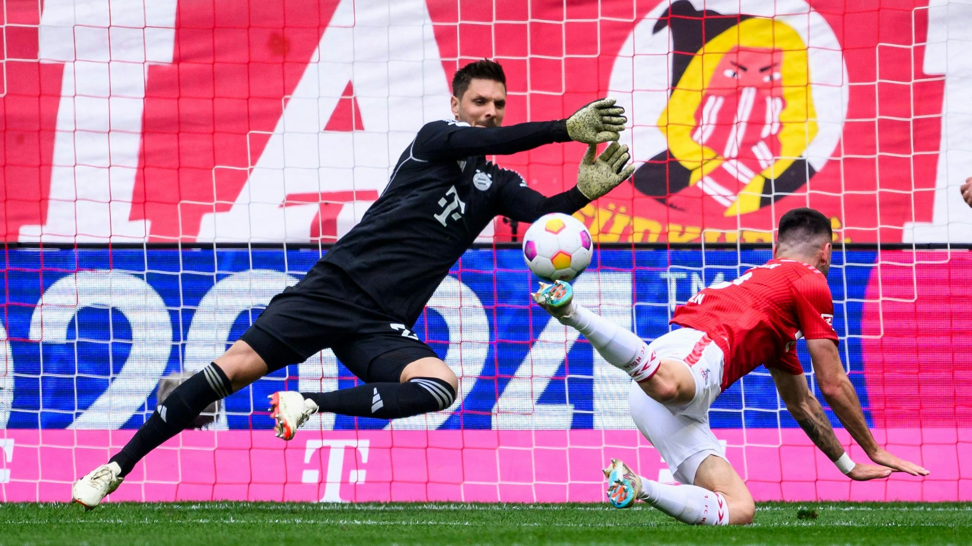 Münchens Torwart Sven Ulreich (l) klärt gegen Kölns Sargis Adamyan (r).