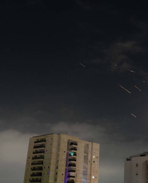 Flammen von Explosionen erscheinen am Himmel über Tel Aviv, während Israels Raketenabwehrsystem Raketen und Drohnen aus dem Iran abfängt.