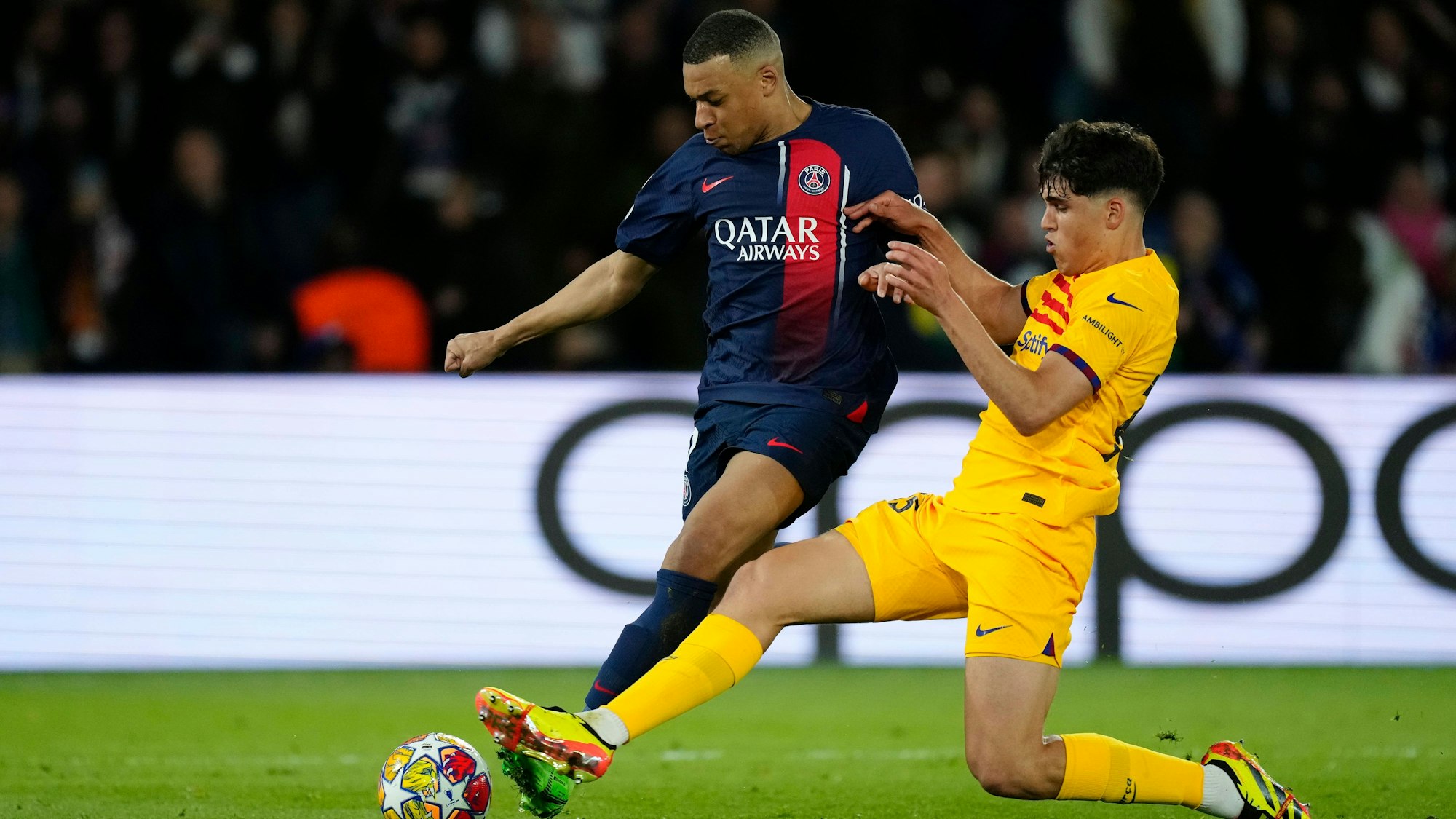 Pau Cubarsí (r.) grätscht in der Champions League im Zweikampf mit Kylian Mbappé.