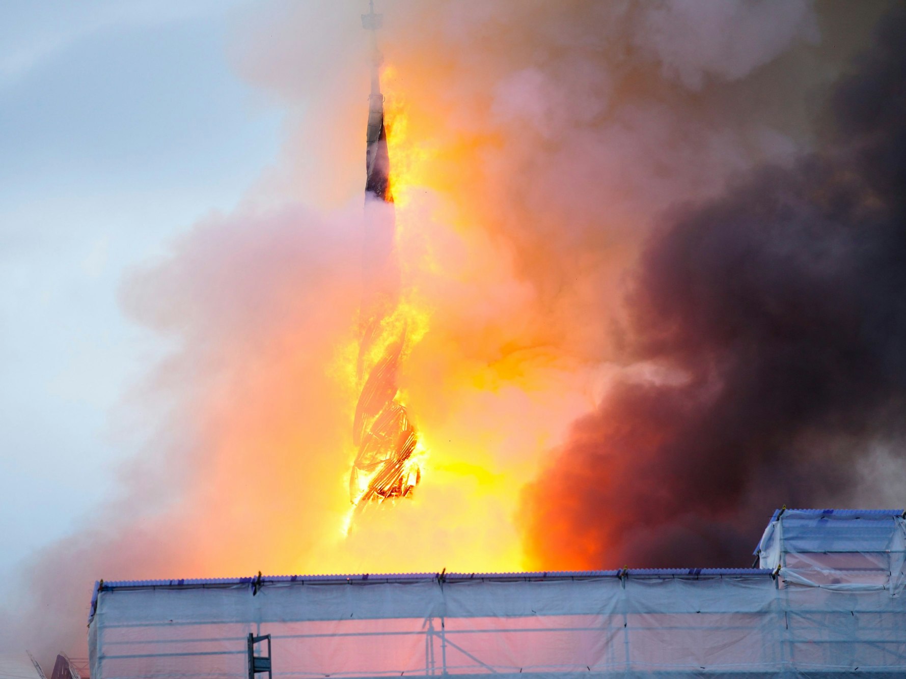 Feuer und Rauch steigen aus der Alten Börse in Kopenhagen auf. Kurze Zeit später stürzt die Turmspitze ein.