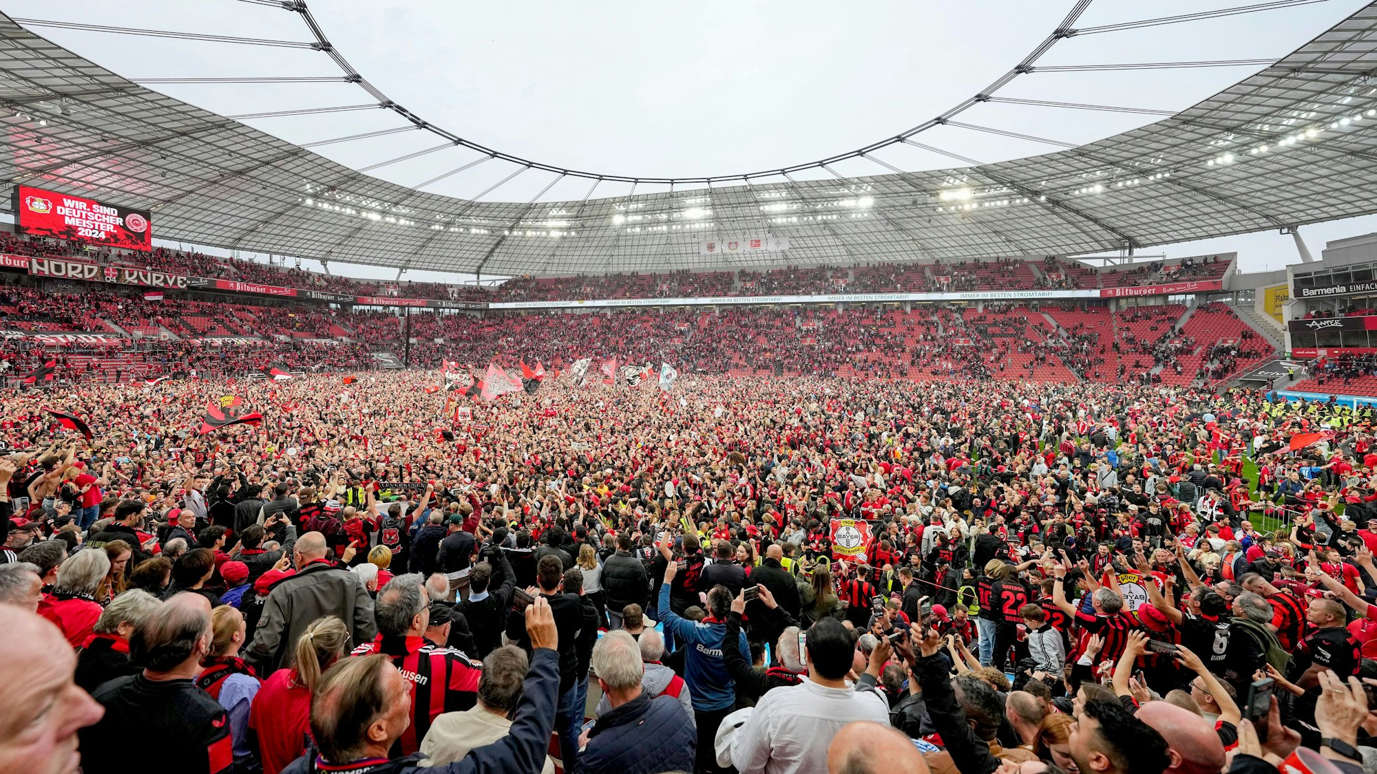 Fans von Bayer Leverkusen stürmen nach dem Gewinn der Deutschen Meisterschaft den Rasen in der BayArena.