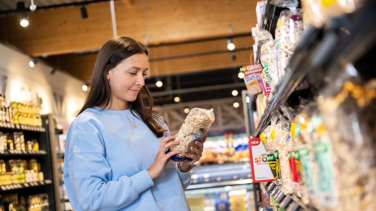 Frau schaut sich Produkt im Supermarkt an.