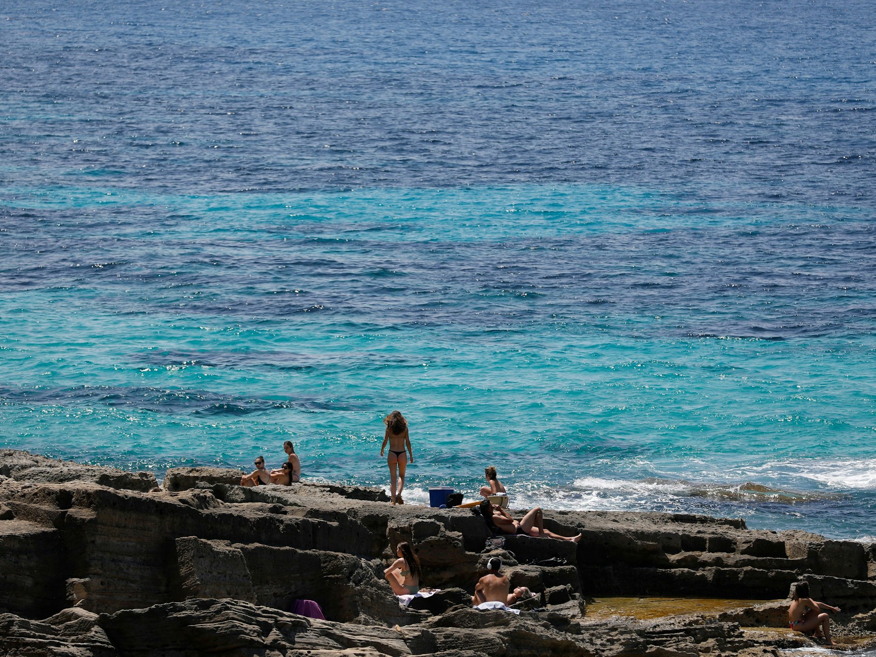 Menschen entspannen sich am Felsenstrand von Maioris an der Südostküste Mallorcas.